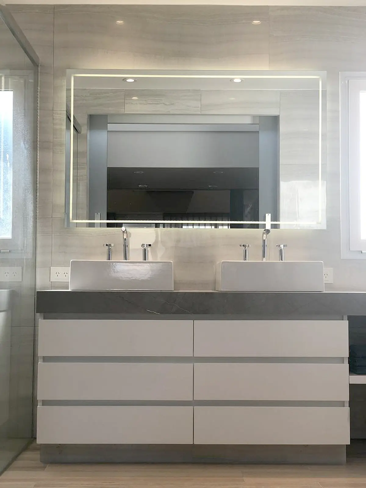 Baño moderno con doble bacha y vanitory flotante iluminado — proyecto Obra Argerich, por Estudio Nicolás Pierry, en CABA
