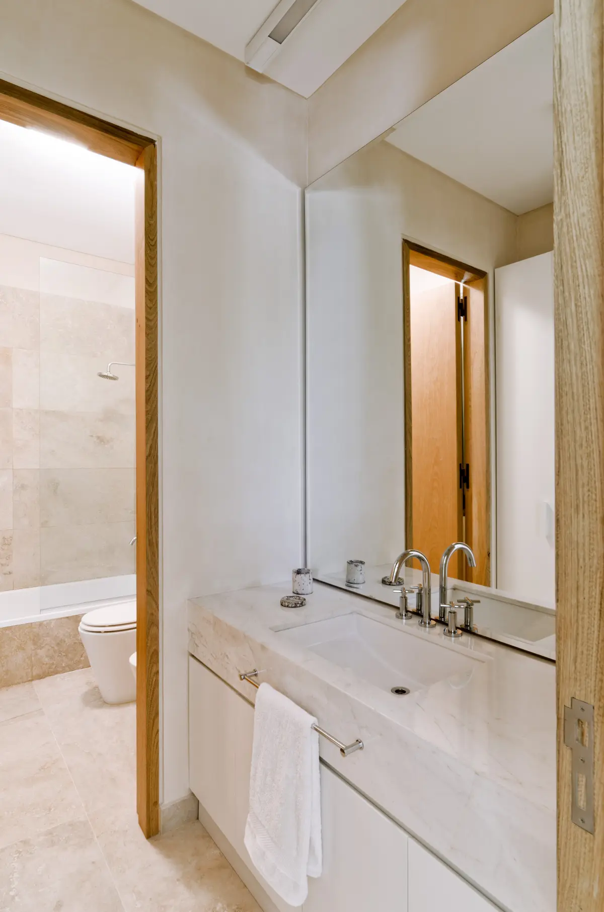 Baño moderno minimalista con mármol y madera — proyecto Casa P, por Estudio Dado, en San Isidro