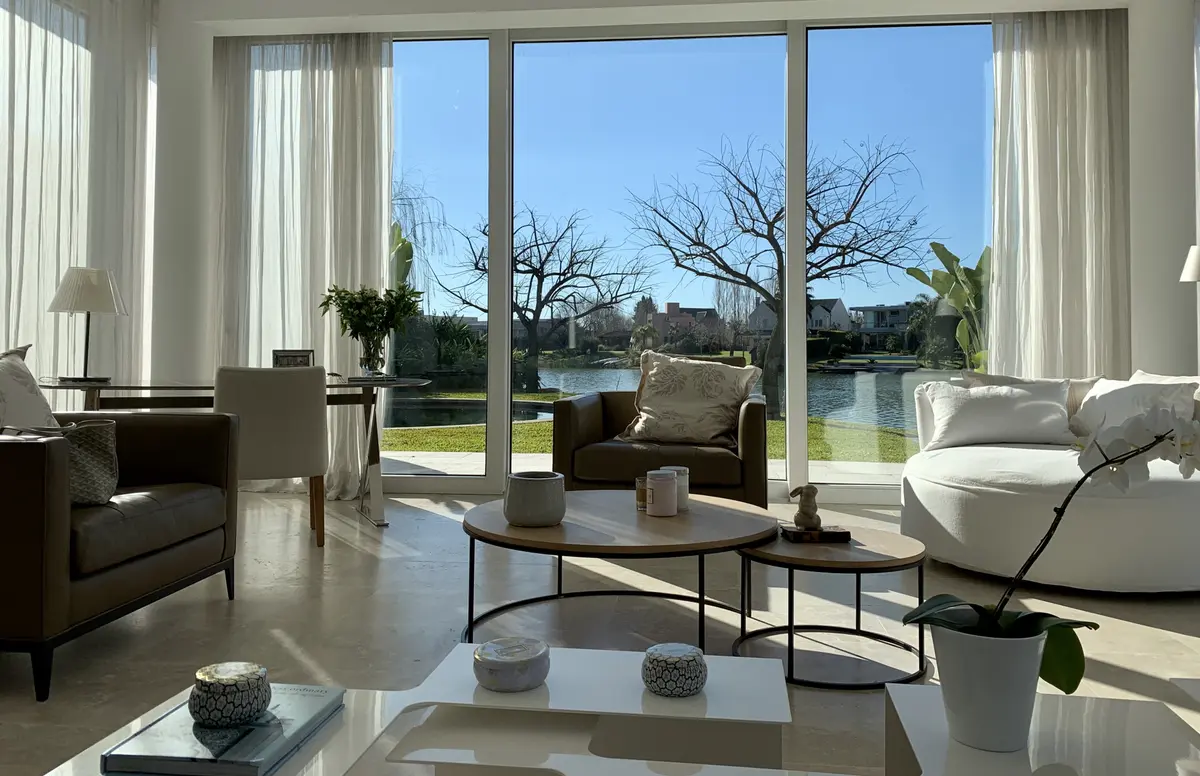Living moderno con ventanales, madera clara y muebles bajos — proyecto CASA LAGUNA, por Estudio Xime Fontan Balestra, en Tigre