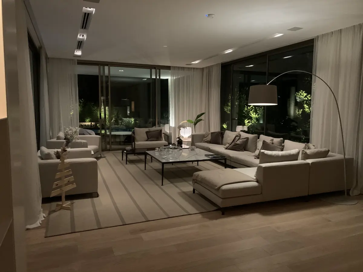Sala de estar moderna com sofá modular e grandes janelas — projeto CASA BECCAR, por Estudio Xime Fontan Balestra, em Béccar