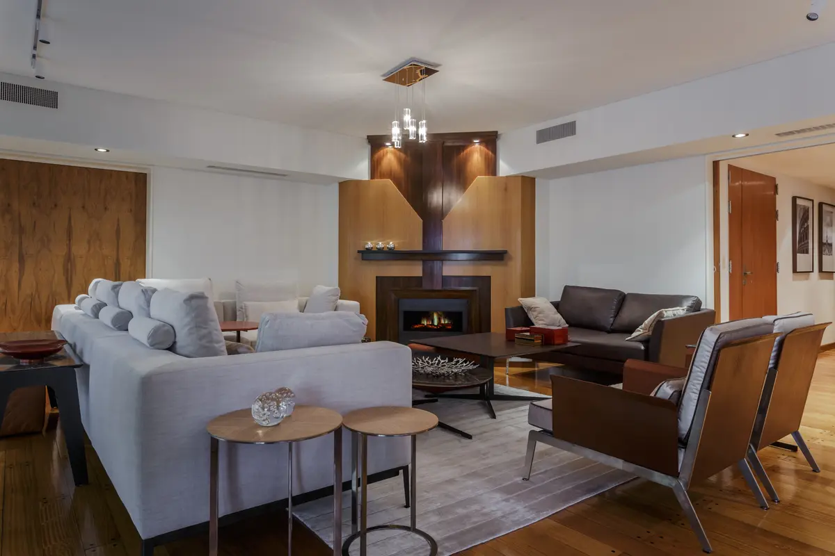 Living comedor moderno con chimenea y paneles de madera — proyecto Piso en Belgrano III, por Gutman+Lehrer Arquitectas, en Belgrano