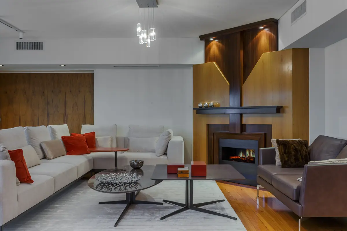 Sala de estar moderna com lareira integrada e painéis de madeira — projeto Piso en Belgrano III, por Gutman+Lehrer Arquitectas, em Belgrano