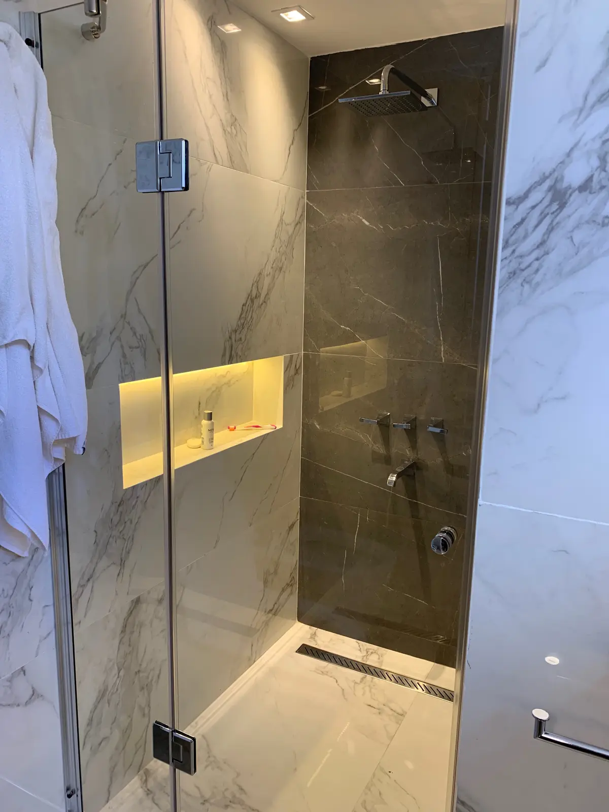 Baño moderno con paredes de mármol y ducha de cristal — proyecto Piso en Nuñez, por Gutman+Lehrer Arquitectas, en Núñez