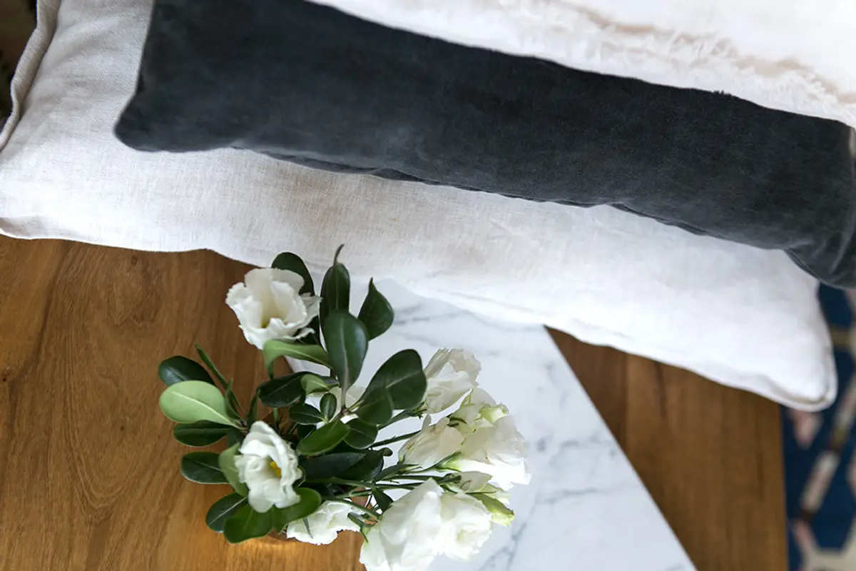 Cama minimalista con almohadones grises y blancos y flores — proyecto BA 3 2016, por Mesopotamia Ba, en CABA