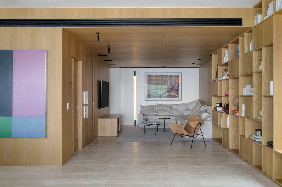 Pasillo con pared de madera y mobiliario integrado que conecta espacios — proyecto PS House, por Studio Ro-ca