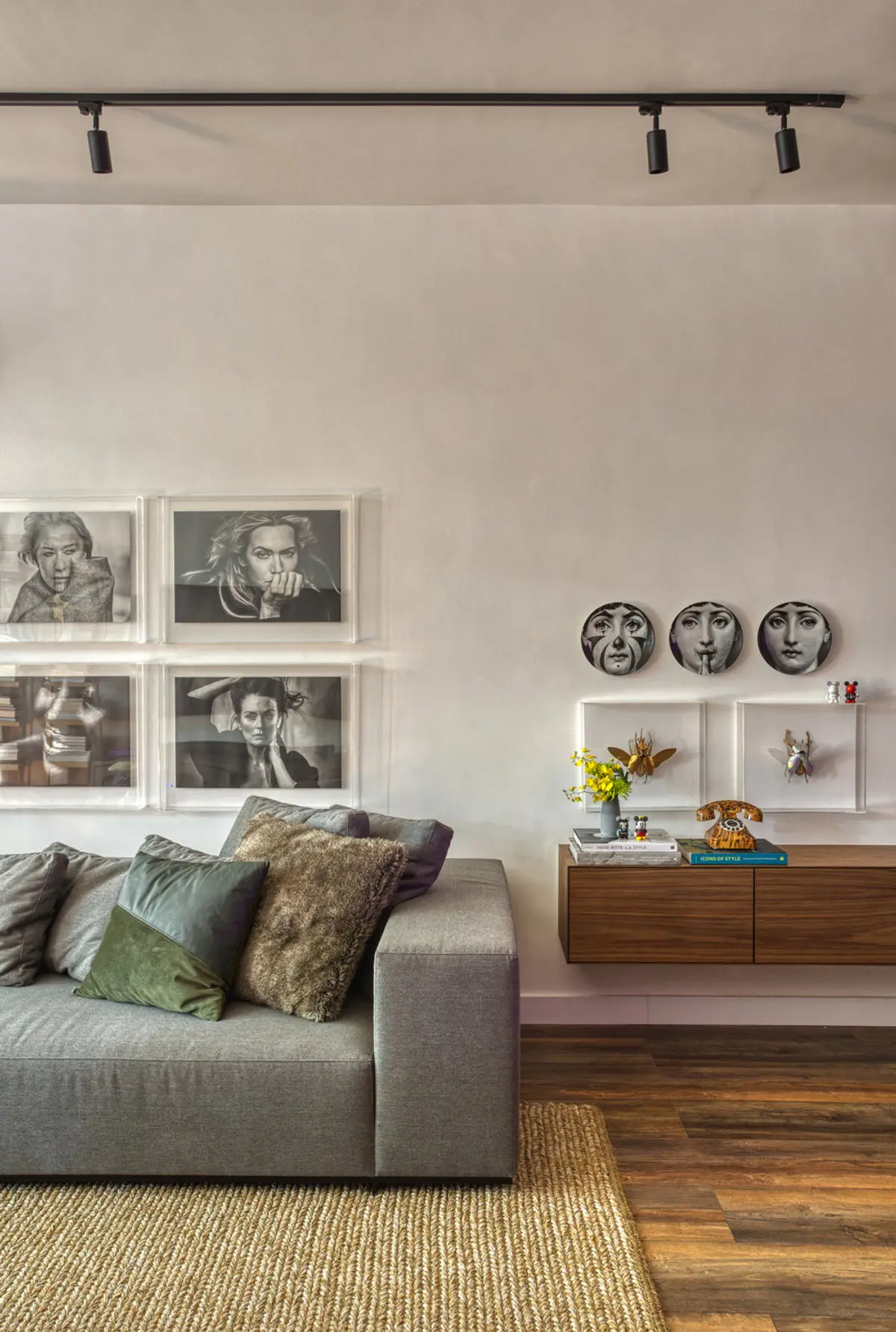 Living minimalista con sofá gris, mueble madera y galería de arte blanco y negro — proyecto Hugo Gloss, por Studio Ro-ca