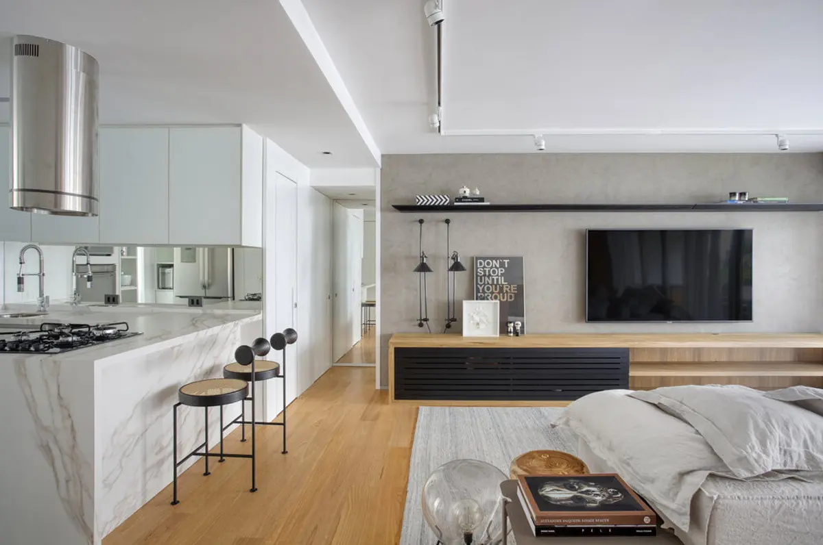 Living integrado cocina con pantalla mural y piso de madera — proyecto JG House, por Studio Ro-ca