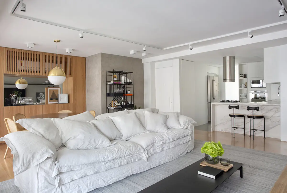 Living moderno con sofa blanco, cocina integrada y detalles en madera — proyecto JG House, por Studio Ro-ca