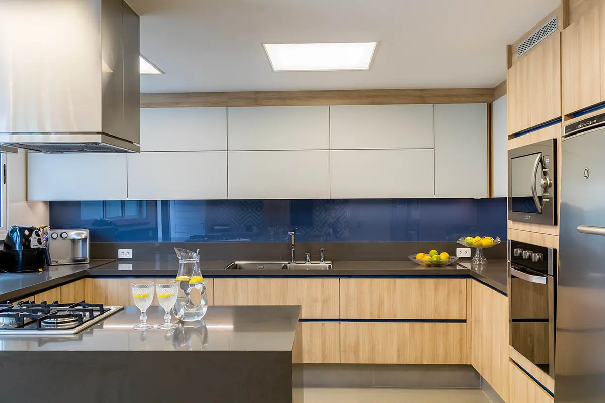 Cocina moderna con isla, mesadas de madera y frente azul marino — proyecto Casa Barra ED, por Amanda Miranda