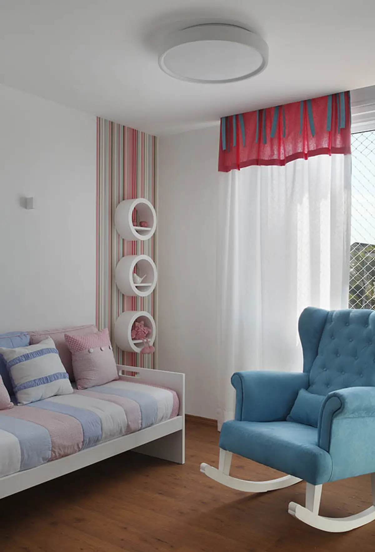 Dormitorio moderno con cama rosa, sillón azul y cortinas rojas — proyecto Casa Barra ED, por Amanda Miranda