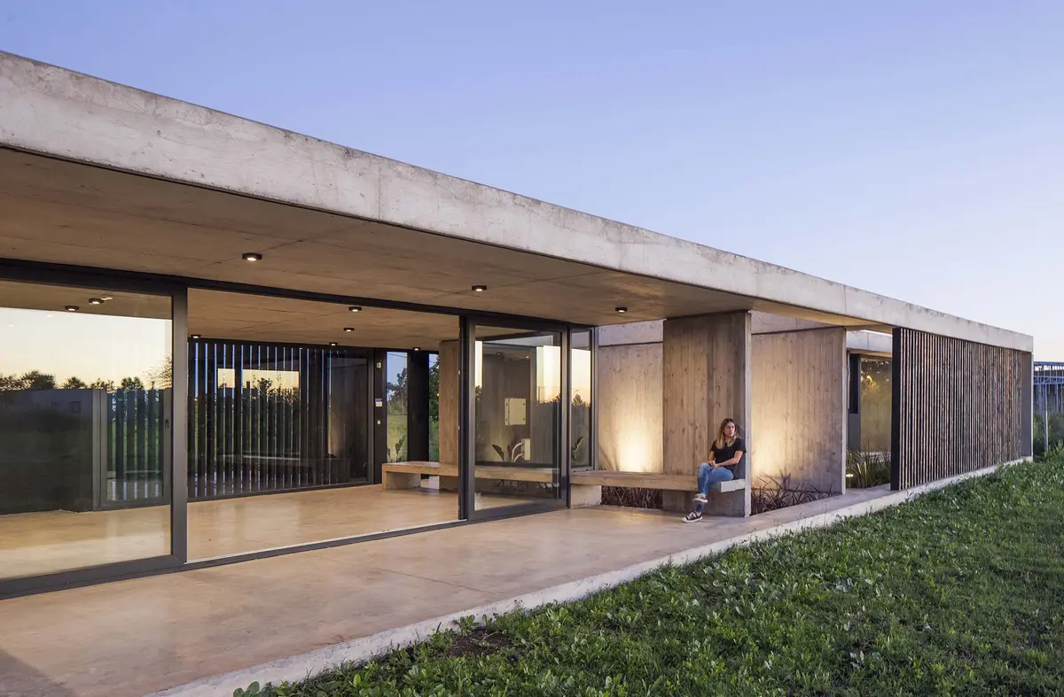 casa moderna de concreto com grandes janelas e beiral — projeto Chacra 93, por V2 Arquitectos, em City Bell