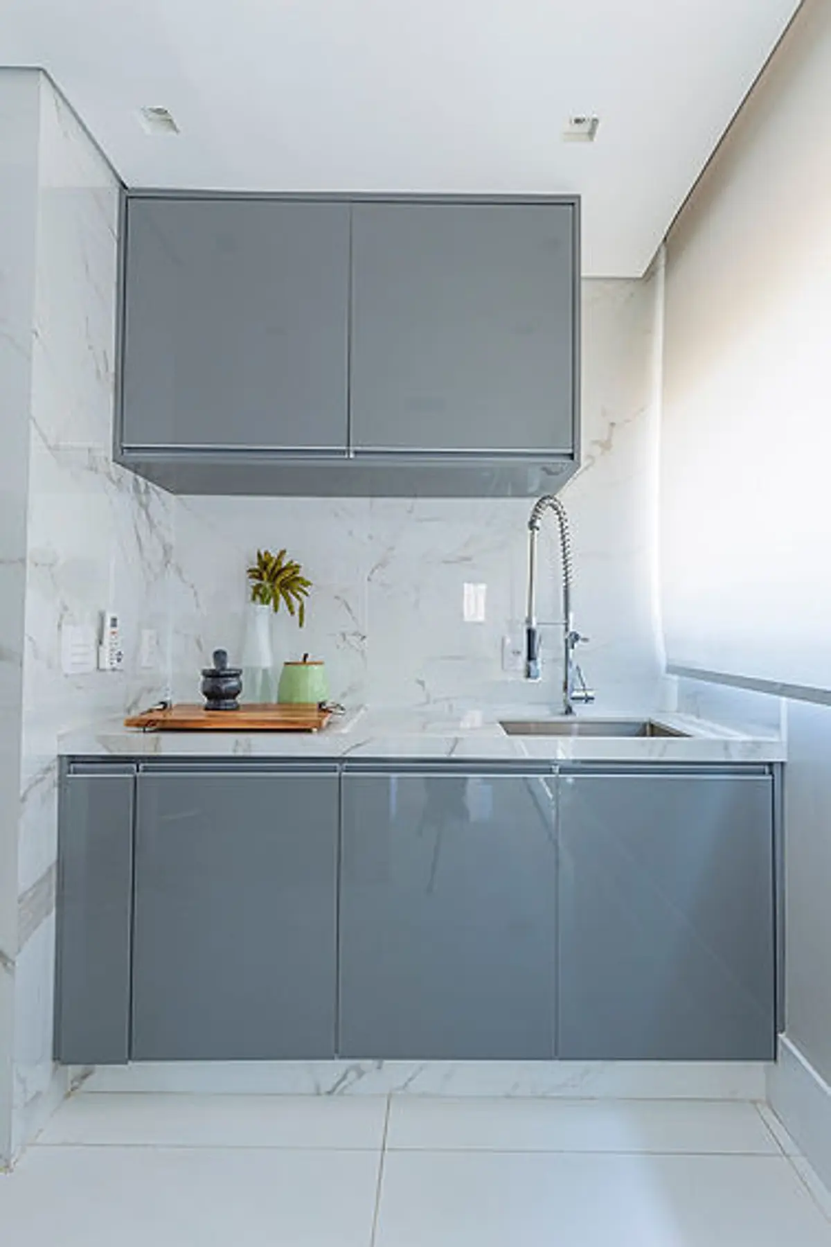 Cocina minimalista con muebles grises, mesada mármol y backsplash blanco — proyecto Apartamento Martese I, por Bordin E Soares Interiores