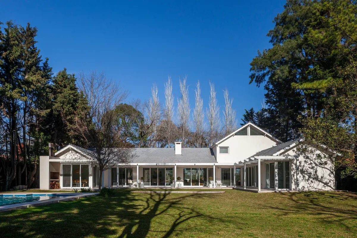 Casa moderna com grandes janelas e deck de madeira em subúrbio — projeto Highland, por Lala Loviscek arquitecta, em Pilar