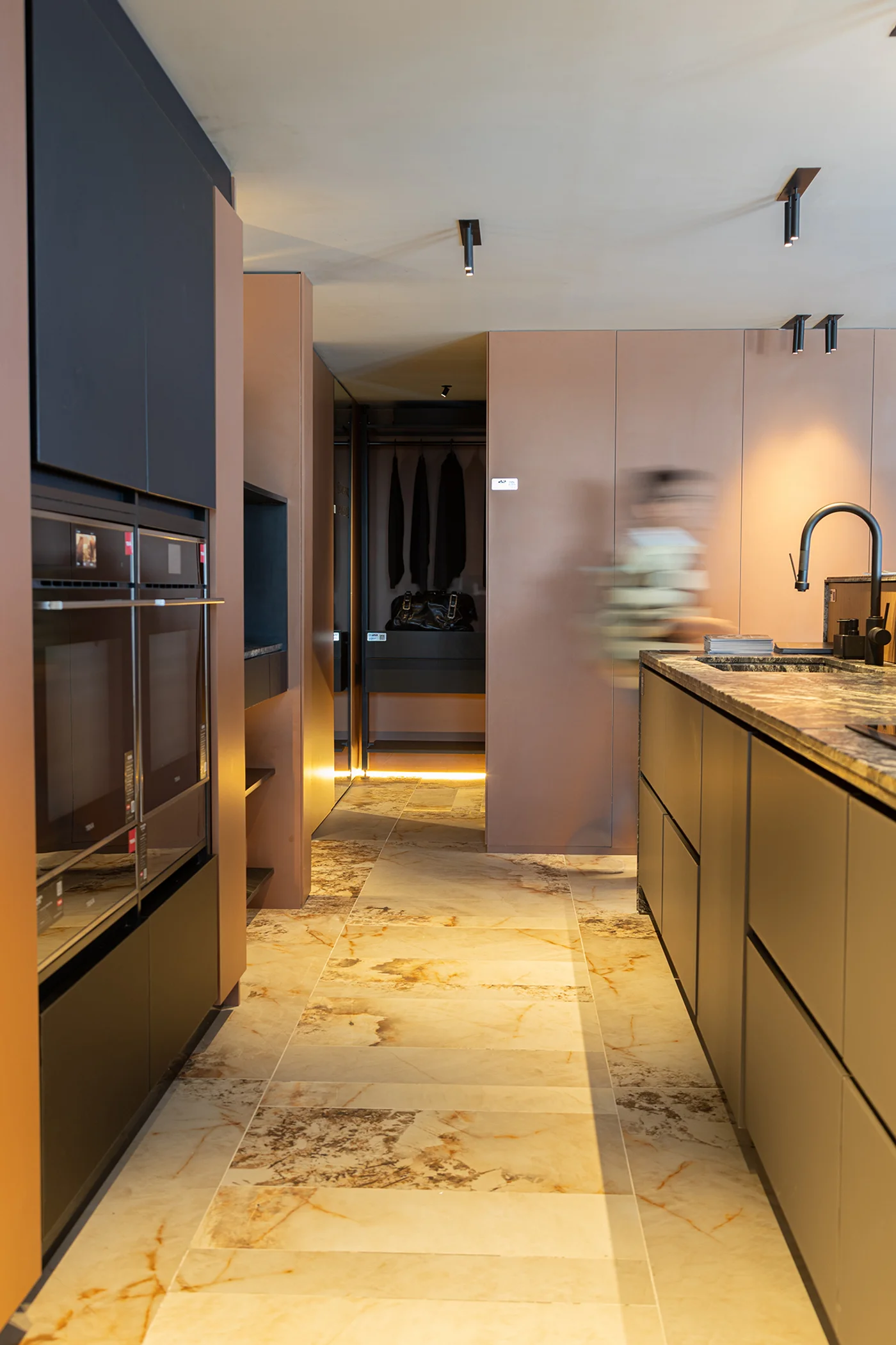 Cocina moderna con pisos de mármol, gabinetes grises y closet visible.
