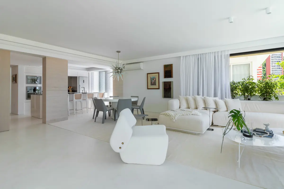 Ampla sala de estar e jantar branca com sofá curvo e lustre dourado — projeto Residencial, por Rodolfo Fontana