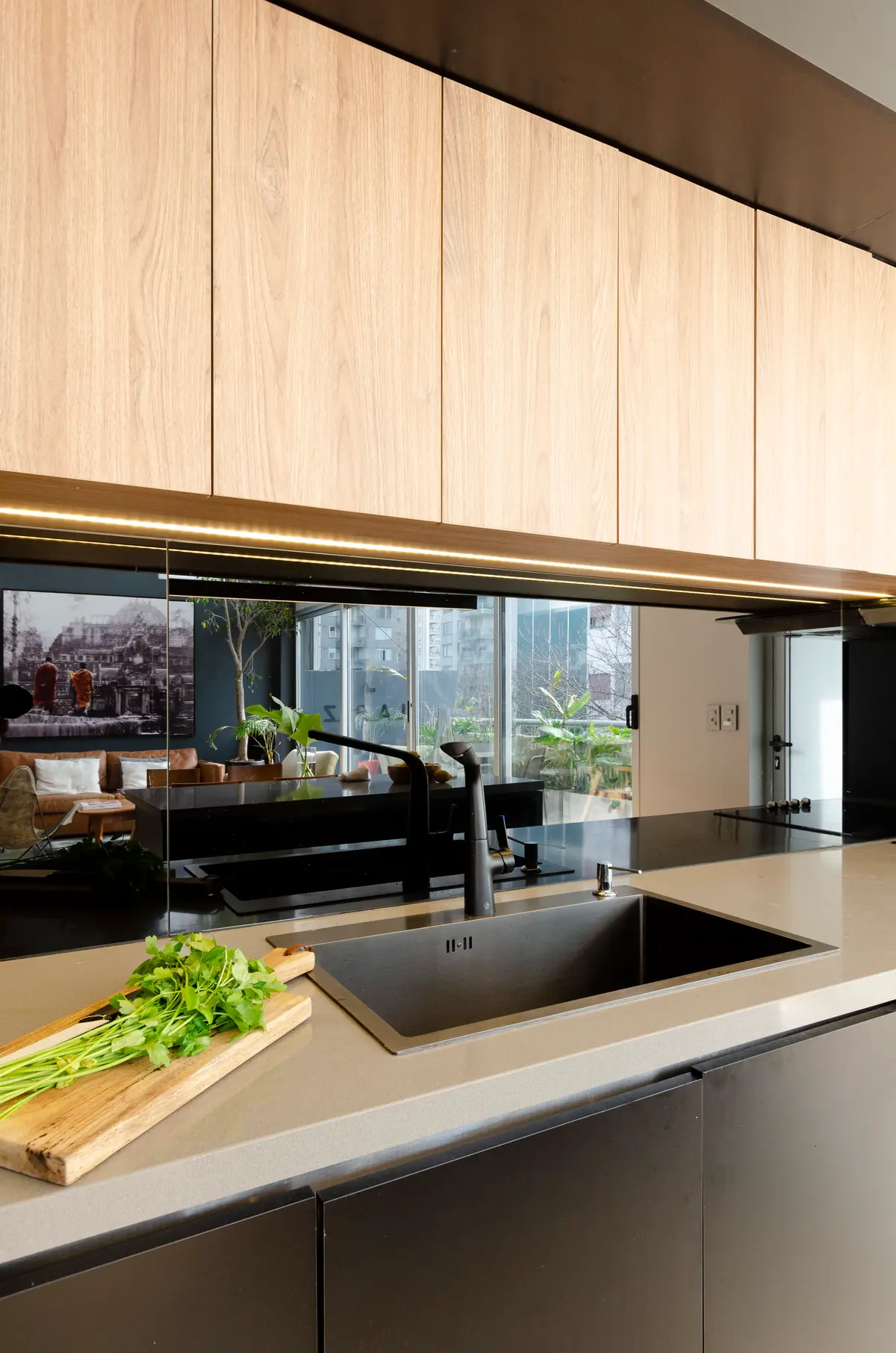 Cocina moderna con muebles de madera clara y luz indirecta — proyecto Guayra - Andrea Gonzales, por ABEJA CONCEPT, en Belgrano