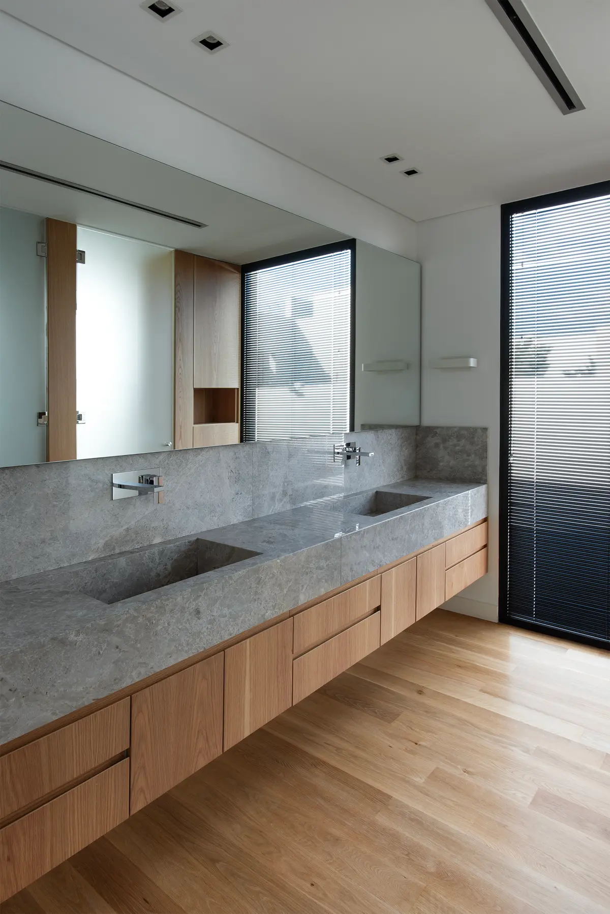 baño moderno con vanitory doble de piedra y muebles de madera flotantes — proyecto CASA SD28, por GMARQ, en Buenos Aires