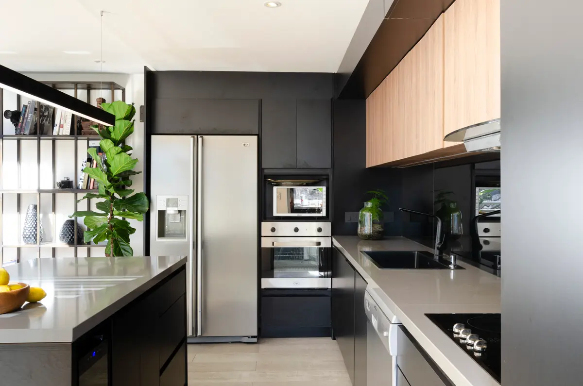 Cozinha moderna em dois tons com ilha central e eletrodomésticos embutidos — projeto Guayra - Andrea Gonzales, por ABEJA CONCEPT, em Belgrano