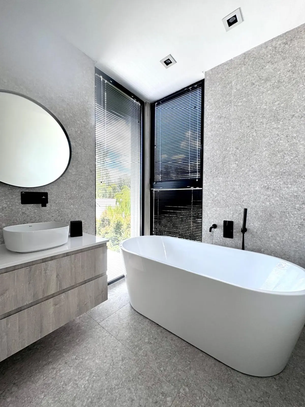Banheiro moderno com banheira freestanding e paredes de pedra — projeto DISEÑO INTERIOR - SAN BENITO - BAÑO SUITE, por FOCO_arquitectura&diseñointerior, em Belén de Escobar