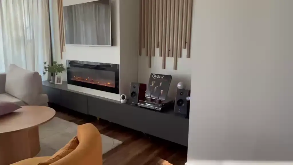 Living moderno con chimenea eléctrica y sofá curvo — proyecto Proyecto 60, por Momas Interiores, en La Plata