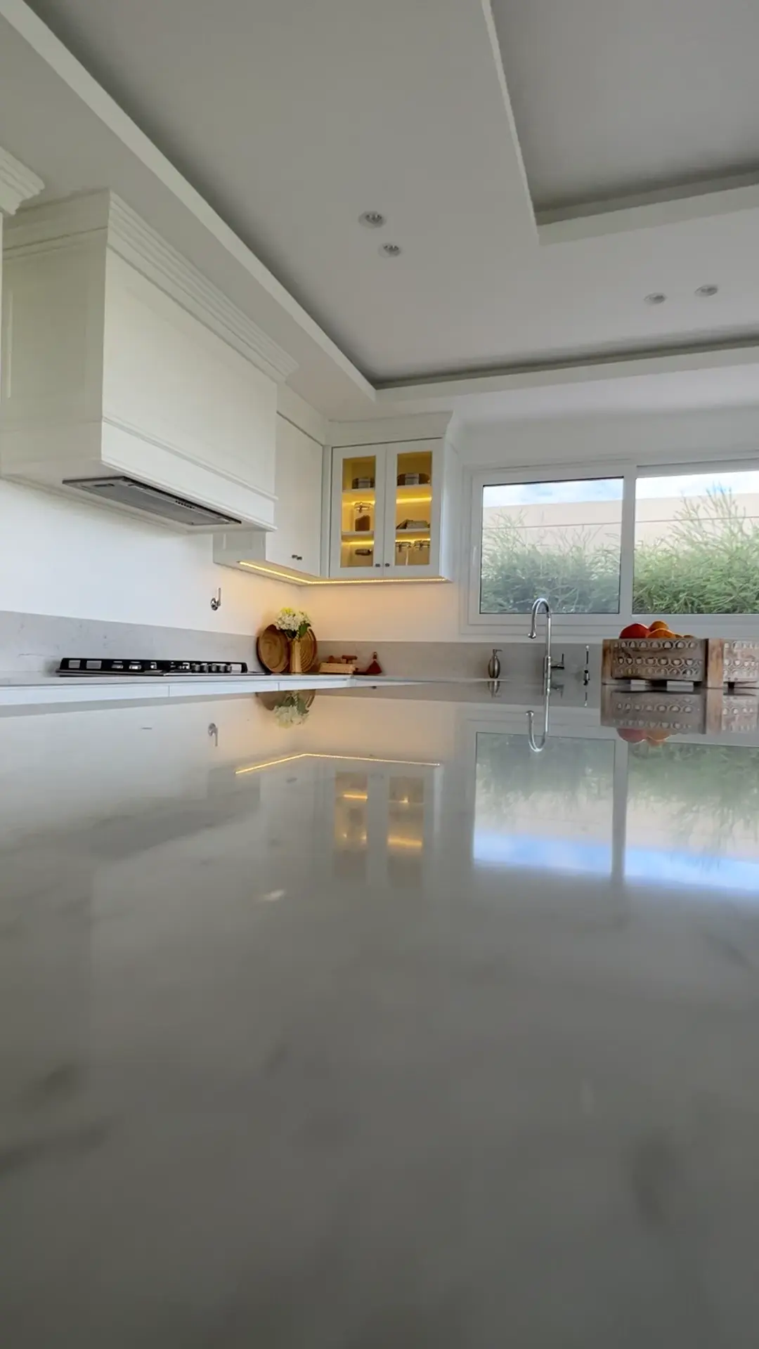 Cocina moderna blanca con mesada de mármol y luces indirectas — proyecto Cocina real , por Wiarq, en Belén de Escobar