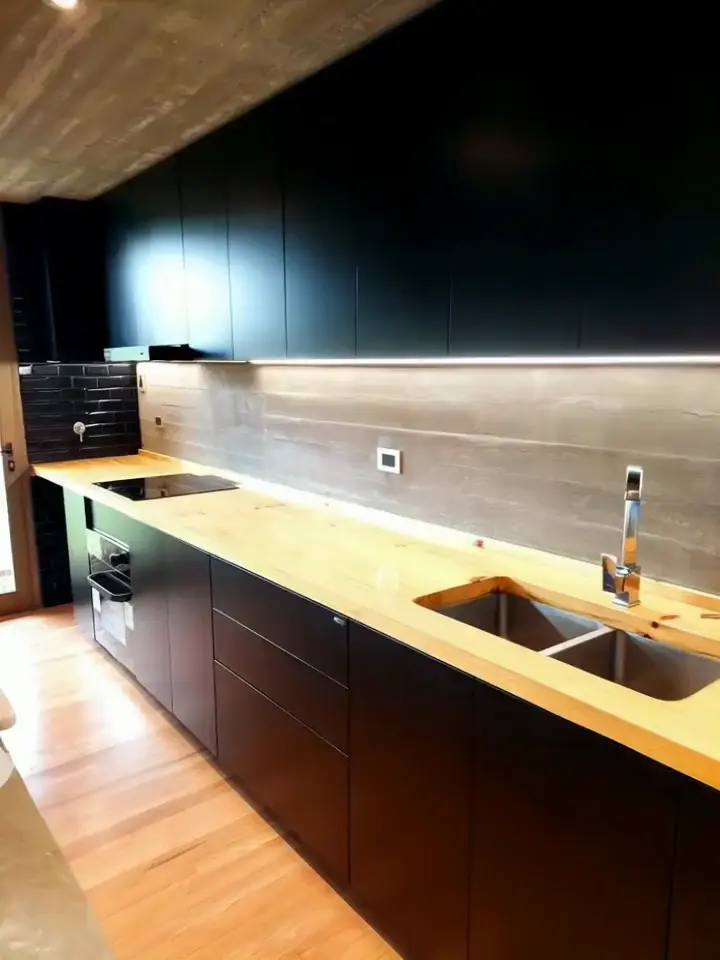 Cocina moderna con muebles negros y mesada de madera — proyecto cocinas, por Tu Mueble, muebles a medida, en Gonnet