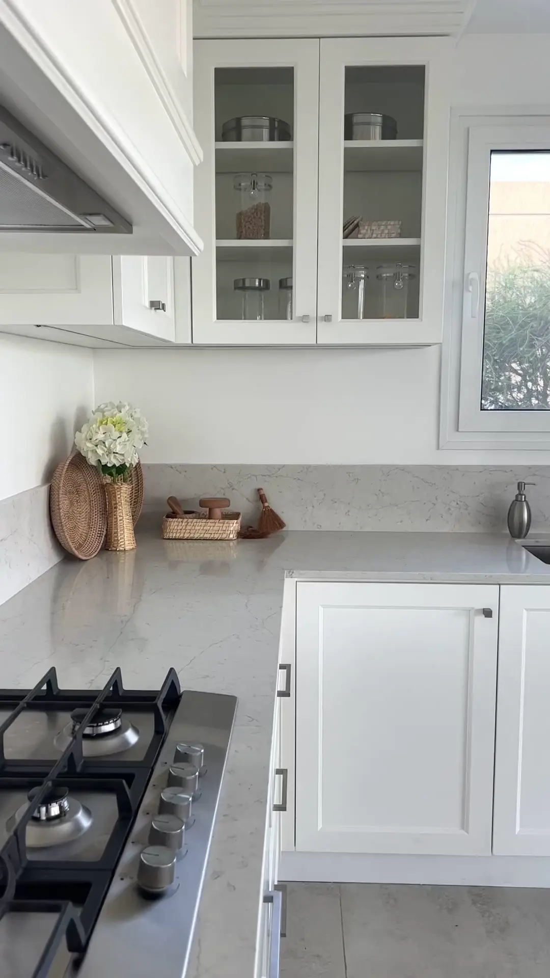 Cocina moderna con gabinetes blancos, mesada de piedra y electrodomésticos de acero inoxidable — proyecto Cocina real , por Wiarq, en Belén de Escobar